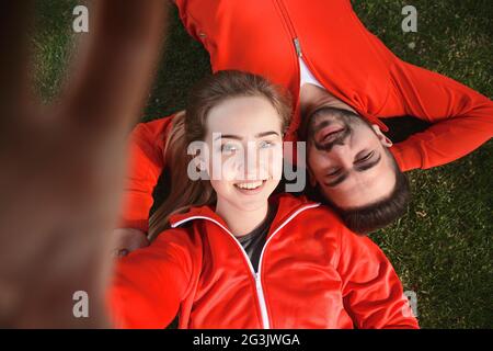 Sport l uomo e la donna che fa selfies in posizione di parcheggio Foto Stock