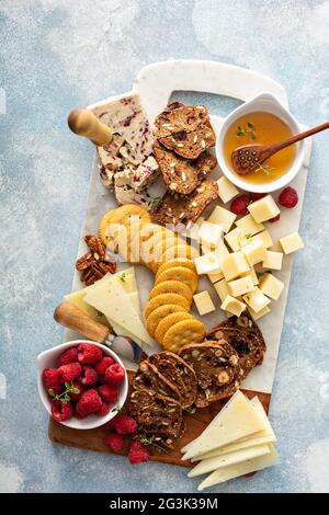 Formaggi e spuntini a bordo con lamponi e cracker Foto Stock