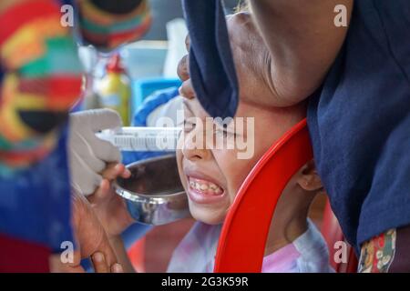 BALI/INDONESIA-MAGGIO 28 2021: Un medico ENT sta esaminando le orecchie, il naso e la gola di un paziente pediatrico. Durante l'esame COVID-19 pandemico, ENT Foto Stock