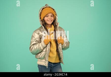 happy kid in giacca e maglieria color argento si scalda in inverno pronto per attività in vacanza, moda invernale Foto Stock