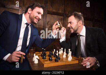 Ricchi uomini d'affari giocando a scacchi Foto Stock