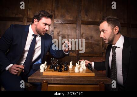 Ricchi uomini d'affari giocando a scacchi Foto Stock