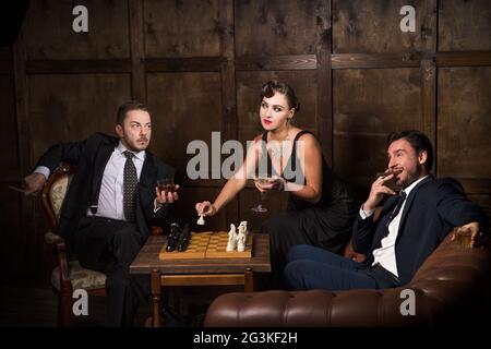 Ricchi uomini d'affari giocando a scacchi Foto Stock