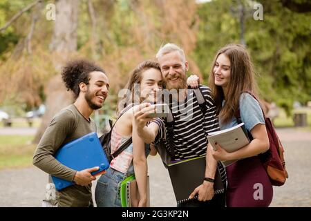 Amici dell'università rendendo selfie sulla fotocamera del telefono. Foto Stock