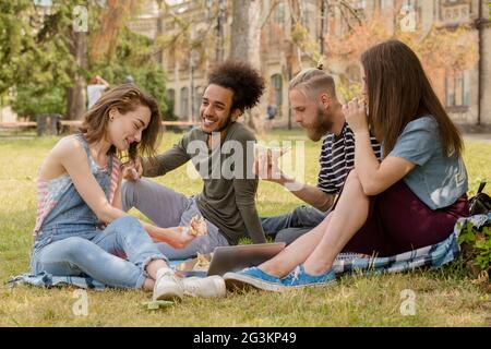 Gli studenti aventi picinic sul prato di fronte all università. Foto Stock