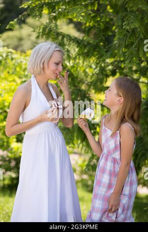 Madre e figlia in piedi in park a mangiare il gelato. Foto Stock