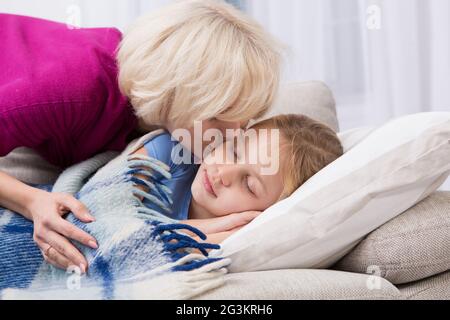 Madre baciando la figlia malata. Foto Stock