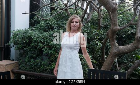 Orientale europea caucasica donna mezza età capelli biondi pelle chiara pallido carnagione in bianco abito fuori estate casual Foto Stock