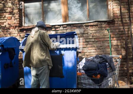 Poor old tramp in search for food or empty bottles. Stock Photo