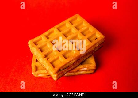 waffle belgi con ripieno su sfondo rosso Foto Stock