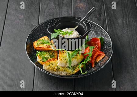 Tostare il pane all'aglio, il pomodoro e il pato di pollo su un piatto Foto Stock