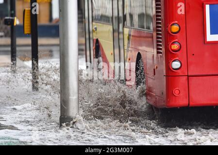 Brighton UK 17 giugno 2021 - autobus guidare attraverso le acque alluvionali sulle strade a Valley Gardens a Brighton dopo una notte di pioggia pesante e tempeste tuose nel Sud Est : Credit Simon Dack / Alamy Live News Foto Stock