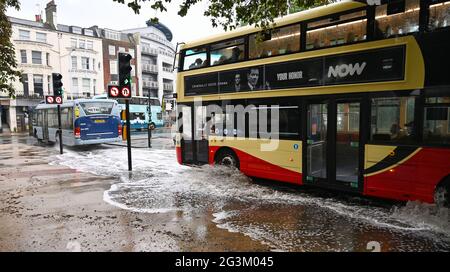 Brighton UK 17 giugno 2021 - autobus guidare attraverso le acque alluvionali sulle strade a Valley Gardens a Brighton dopo una notte di pioggia pesante e tempeste tuose nel Sud Est : Credit Simon Dack / Alamy Live News Foto Stock
