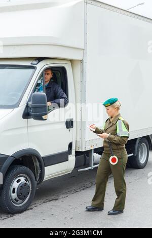 Una guardia di frontiera femminile controlla i documenti Foto Stock