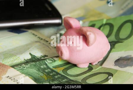 Banca di piggy su sfondo di banconote Foto Stock