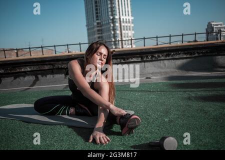 Centro Fitness sul tetto, ragazza sportivo facendo stretching. Foto Stock