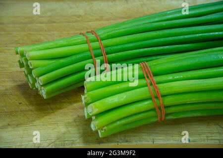 Fiore di cipolla, cepa di allio, cipolla gallese, fiore di allio su tagliere. Foto Stock