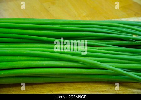 Fiore di cipolla, cepa di allio, cipolla gallese, fiore di allio su tagliere. Foto Stock