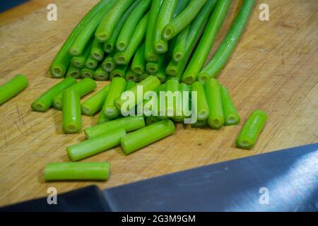 Fiore di cipolla, cepa di allio, cipolla gallese, fiore di allio su tagliere. Foto Stock