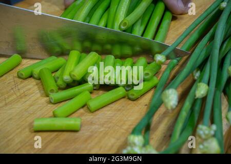 Fiore di cipolla, cepa di allio, cipolla gallese, fiore di allio su tagliere. Foto Stock