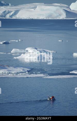 Barca da pesca di fronte agli iceberg Foto Stock