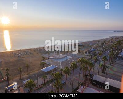 Vista aerea superiore con vista sulla pausa della giornata presso la passeggiata delle palme di Finnikoudes nella città vecchia di Larnaca, Cipro. Si alza il sole sulla superficie del mare. Foto Stock