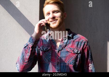 Bel giovane che parla al telefono. Foto Stock