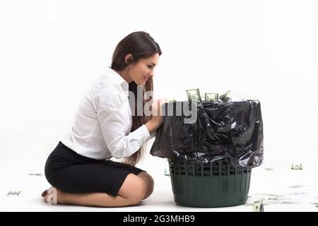 Ragazza seduta accanto al cestino. Foto Stock