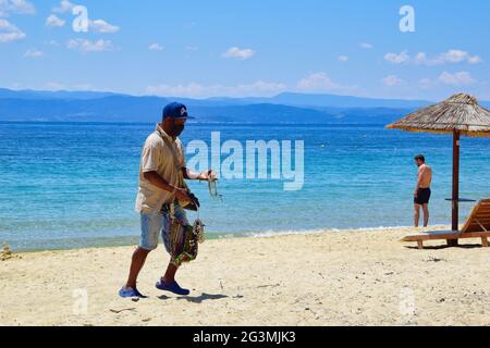 SKIATHOS, GRECIA - 13 giugno 2021: Estate 2021, peddler vende gioielli fatti a mano, Koukounaries spiaggia, Skiathos, Grecia, 6-13-2021 Foto Stock