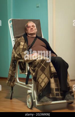 Ritratto di uomo caucasico maturo con la spalla bendata e la ferita sulla fronte che giace premuto nel trasporto dell'ospedale dopo l'incidente della bicicletta Foto Stock