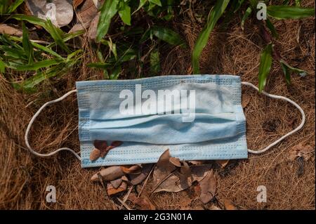 '02.04.2021, Singapore, , Singapore - UN guardiano del bocca usato e scartato per proteggere contro l'infezione con il coronavirus (Covid-19) si trova sul terreno. Foto Stock