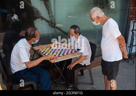 '25.05.2021, Singapore, , Singapore - gli anziani che indossano guardie della bocca giocano a scacchi cinesi (Xiangqi) a Chinatown durante la crisi di Corona in corso (Cov Foto Stock