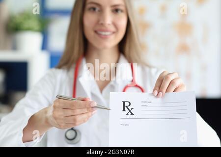 Donna medico che tiene la mano dà prescrizione al closeup del paziente Foto Stock