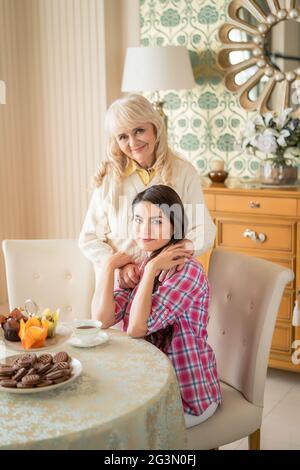 Abbracci amorevoli tra madre anziana e figlia giovane. Foto Stock