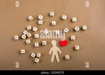 Cubetti di lettere di legno e figurine dell'uomo e forma del cuore Foto Stock