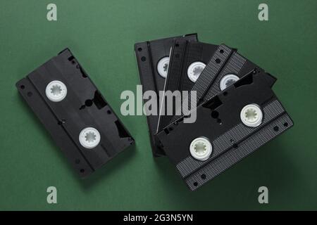 Pila di videocassette retrò su sfondo verde. Vista dall'alto Foto Stock