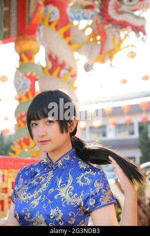 donna di bellezza indossa cheongsam blu guardando e sorridere in cinese anno nuovo Foto Stock