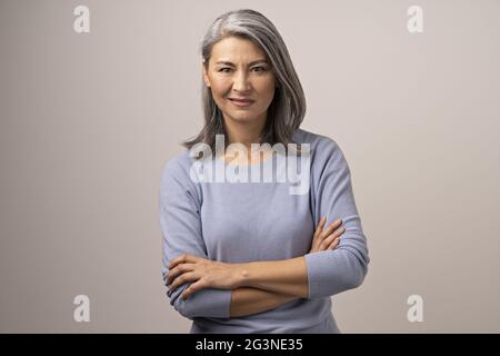 Asian senior donna con bracci incrociati mostra dissproval Foto Stock