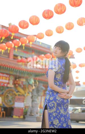 donna di bellezza indossa cheongsam blu guardando e sorridere in cinese anno nuovo Foto Stock