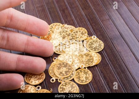 Molte monete d'oro finte in mano Foto stock - Alamy