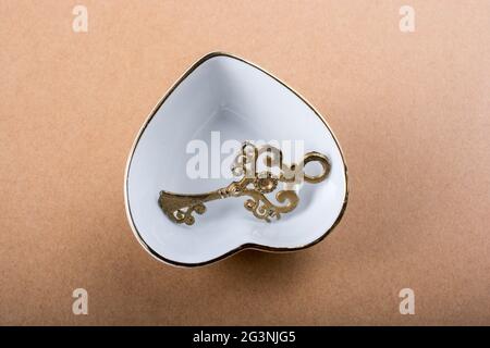 Chiave decorativa in stile retrò e ciotola a forma di cuore Foto Stock