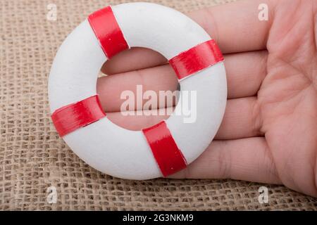 Mano che tiene un Lifesaver sul tessuto Foto Stock