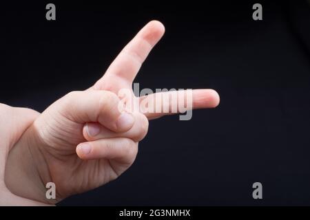 Mano che mostra il segno della vittoria e della pace Foto Stock