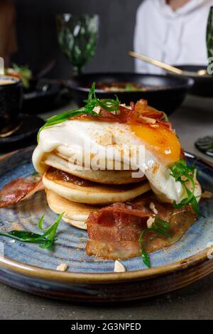 Pancake con pancetta, uova fritte e formaggio fuso Foto Stock