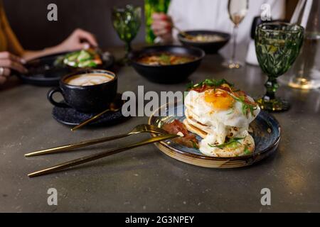 Pancake con pancetta, uova fritte e formaggio fuso Foto Stock