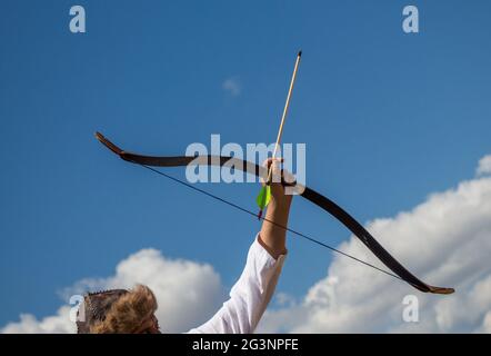 Archer in abiti tradizionali sparando una freccia Foto Stock