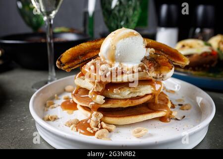 Frittelle con banana, caramello e paletta per gelato Foto Stock