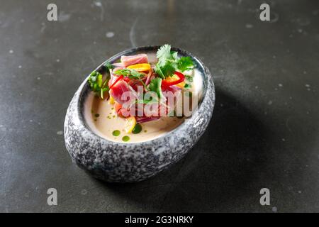 tartare di tonno con peperoncino alla cipolla al limone di pomodoro ed erbe fresche in stoviglie Foto Stock