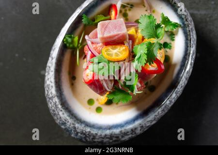 tartare di tonno con peperoncino alla cipolla al limone di pomodoro ed erbe fresche in stoviglie Foto Stock