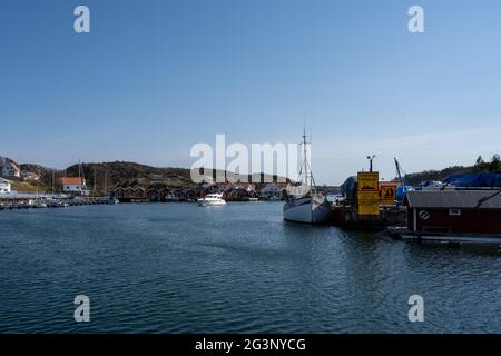 17 aprile 2021 - Hamburgsund, Svezia: Un pittoresco villaggio di pescatori sulla costa occidentale svedese. Tradizionali capanne di mare rosso e un cielo blu sullo sfondo Foto Stock